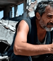 男子于废墟中抱头蹲坐66#横屏 